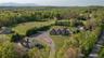 Aerial view of property showing primary residence, guest house and tree-lined privacy boundary.