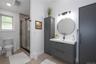 Full bath featuring tile floors, tiled and glass shower, and stylish vanity.