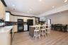 Black appliances, floating island bar and tasteful backsplash.