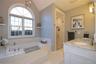 Primary Bath with garden tub, separate shower, double vanity, tile flooring and palladian window.