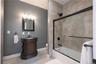 Beautiful bath with tile and glass shower/tub combo, tile flooring and chic finishes