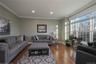Peaceful, separate family room with hardwood flooring, ornamental crown molding, large windows and recessed lighting.