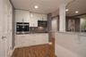 Kitchen featuring white cabinetry, stainless appliances, recessed lighting and dining area.