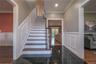 Stairway with wainscoting, crown molding and recessed lighting