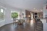 Dining area featuring tile flooring, crown molding, recessed lighting, wainscoting, breakfast bar and a view of the deck and pool complex.