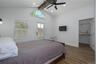 Main level bedroom with gleaming floors, a spacious closet, ceiling fan, recessed lighting and direct access to rear fenced patio.