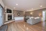 Living room featuring ornamental molding, a gas fireplace, wood finished floors, recessed lighting, and space to gather.
