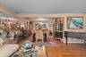 Hardwood flooring extends throughout this expansive interior space, featuring a dining area with a chandelier