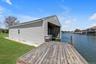 Boathouse with a dedicated slip, featuring gray horizontal siding and a gable roofline