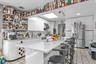 Open-concept kitchen featuring an expansive island with seating, white cabinetry, a built-in wine rack, and a skylight