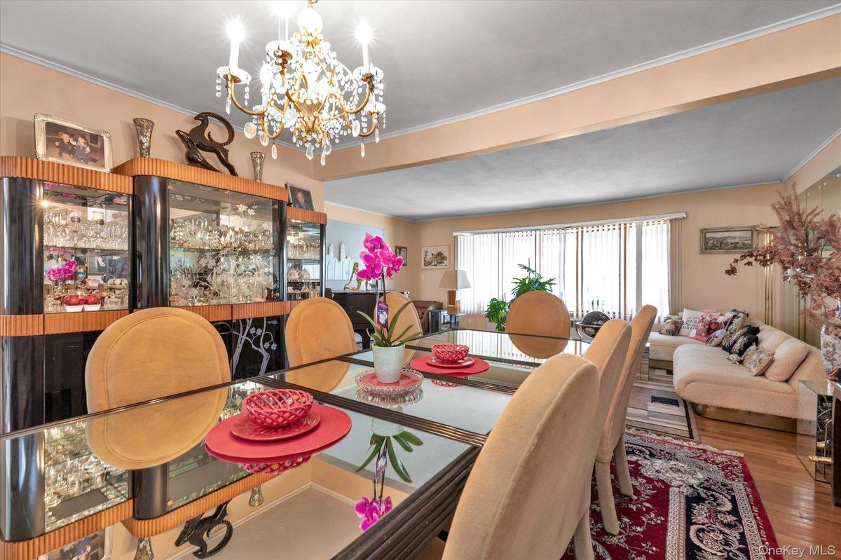 Dining area featuring a mirrored table, chandelier lighting, wood-finish flooring, built-in display cabinetry
