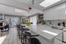 Kitchen featuring a spacious island with seating, white cabinetry, and a large skylight