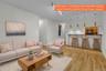 Open concept living area featuring wood-finish flooring and a breakfast bar