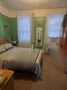 Bedroom with a textured ceiling, carpet flooring, and cooling unit