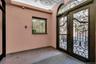 Ornate wrought iron double entry doors with arched transom window, a decorative ceiling medallion, and a granite-look floor