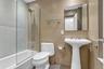 Pedestal sink with brushed nickel faucet, large wall mirror, and glass shower enclosure with subway tile surround