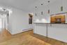 Breakfast bar featuring a dark countertop, supported by metal brackets and legs, illuminated by four pendant lights