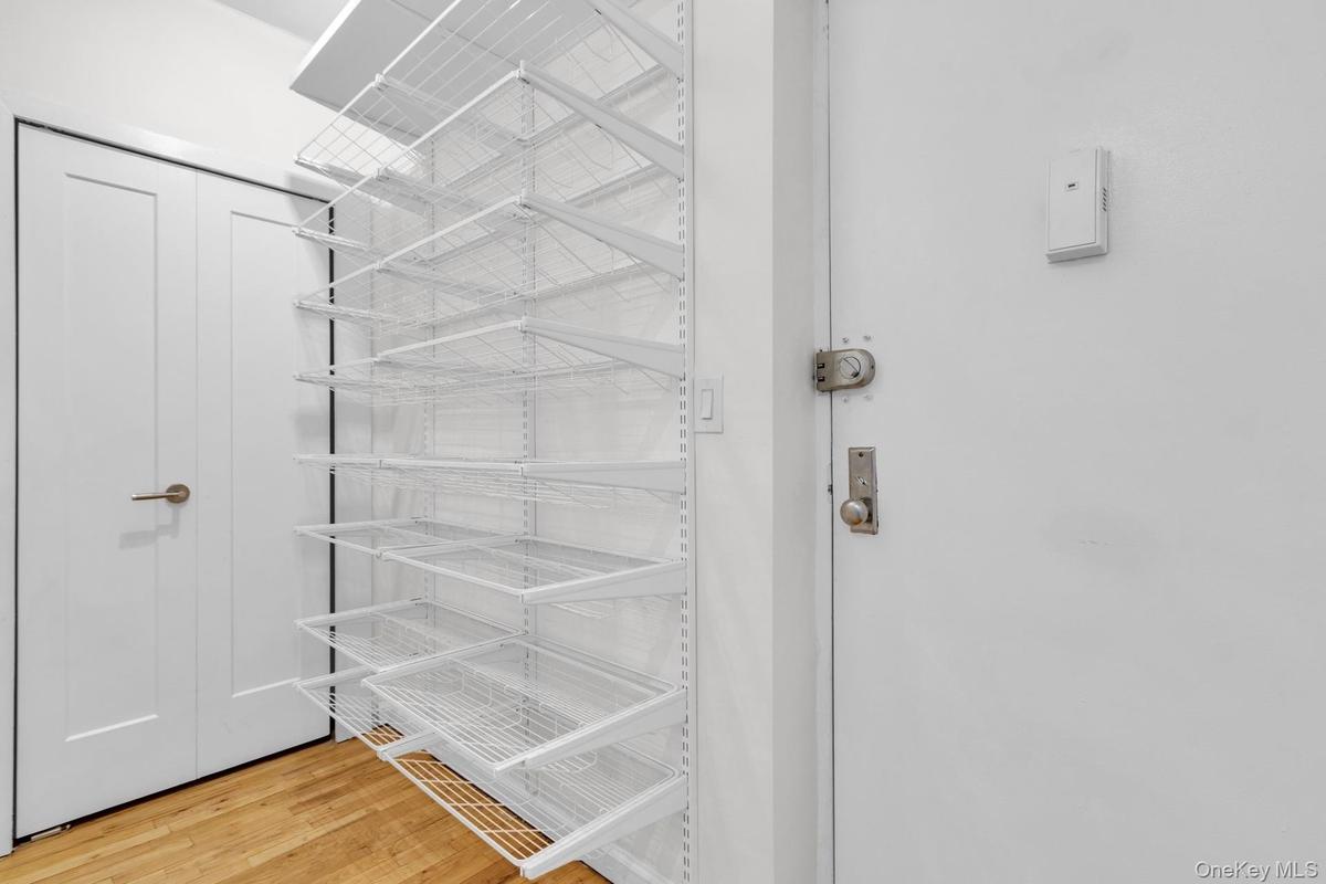 Entrance foyer featuring storage closet and built-in sliding shoe racks.