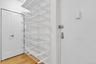 Entrance foyer featuring storage closet and built-in sliding shoe racks.