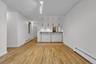 Open concept living area featuring wood-finish flooring, white walls, and track lighting