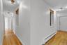 Hallway featuring wood-finish flooring and white painted walls