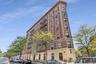 Distinctive wedge-shaped building featuring red brick and light-colored stone detailing