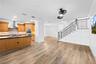 Entertainment area with view of kitchen and stairs