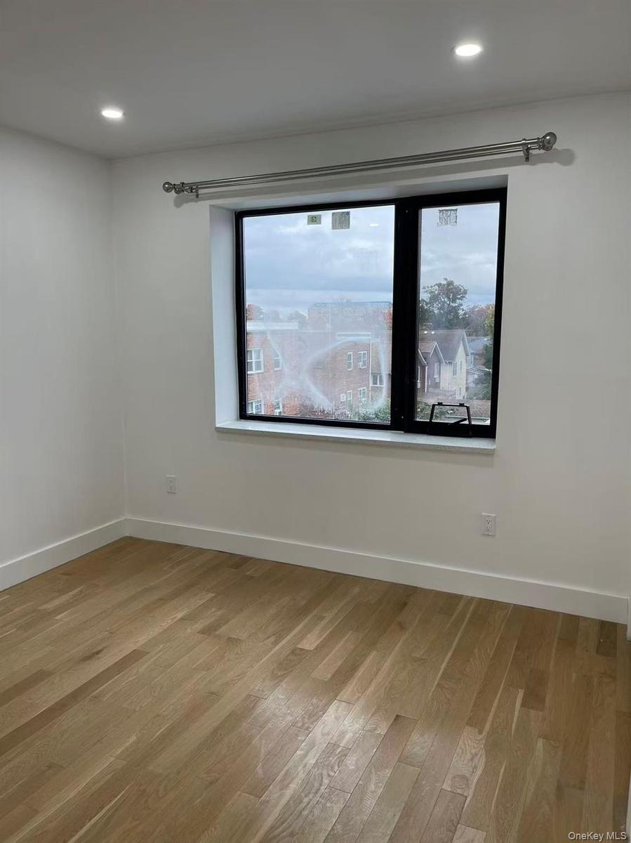 Room featuring a large window with black trim, recessed lighting, and light wood-finish flooring