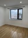 Room featuring a large window with black trim, recessed lighting, and light wood-finish flooring