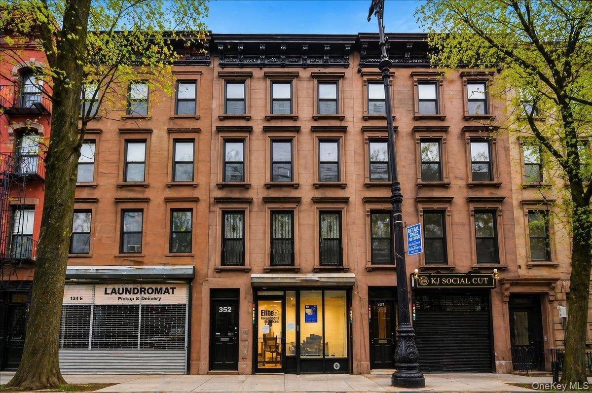 Four-story brownstone building featuring a classic facade with multiple window configurations