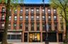 Four-story brownstone building featuring a classic facade with multiple window configurations