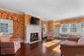 Ensuite Primary Bedroom room with crown molding, with fireplace, and hardwood floors and access to private sunroom