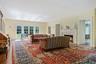 Living room with a decorative wall, wood finished floors, healthy amount of natural light, a lit fireplace, and ornamental molding