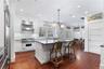 Kitchen featuring white cabinetry, a center island, premium range, pendant lighting