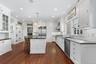 Kitchen with pendant lighting, a center island, high quality appliances, and white cabinetry