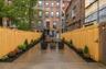 Paved patio with string lighting and planted garden beds Virtually Staged