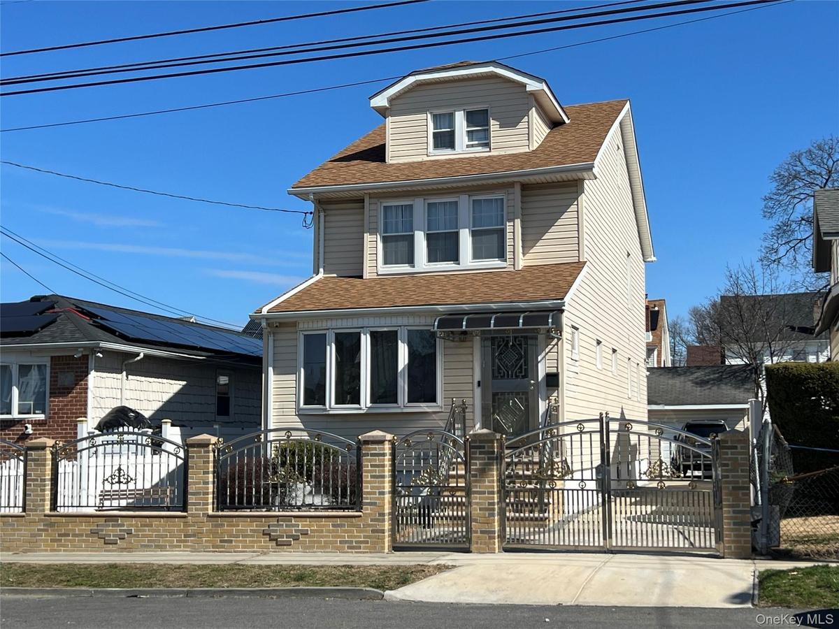 Two-story residence featuring light-colored siding and a dormer window