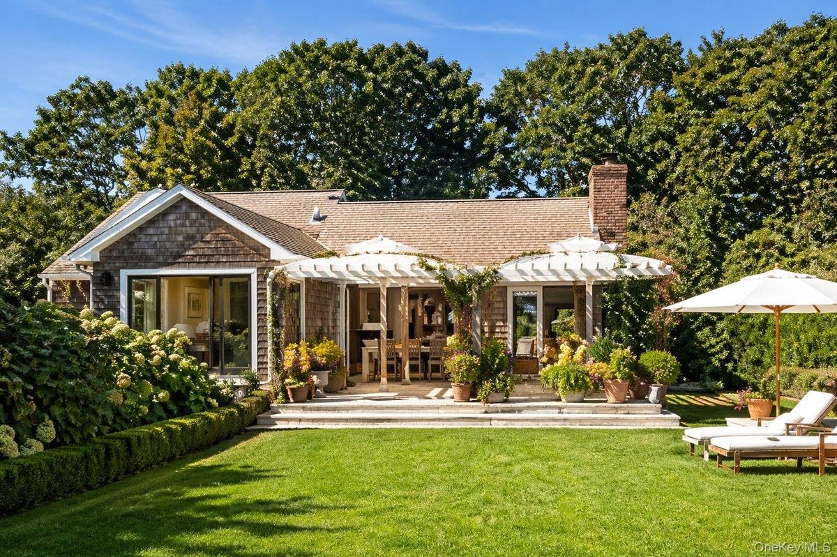 Rear exterior overlooking the landscaped lawn, pool and outdoor living areas.