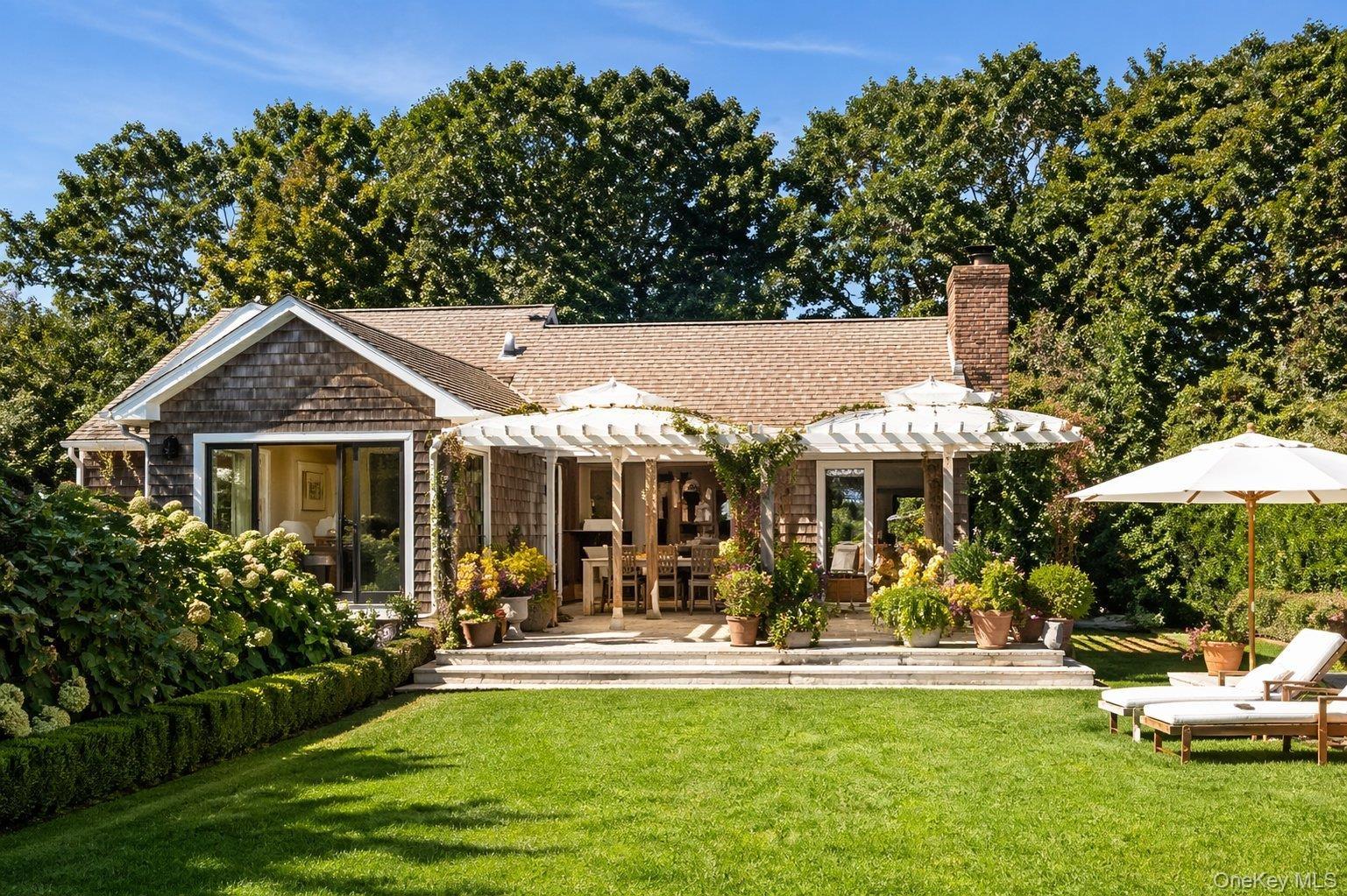 Rear exterior overlooking the landscaped lawn, pool and outdoor living areas.