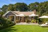 Rear exterior overlooking the landscaped lawn, pool and outdoor living areas.