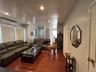 Spacious interior featuring warm wood-finish flooring, recessed lighting, and split-system air conditioning