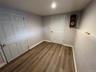 Room featuring wood-finish flooring, light grey walls, and white trim