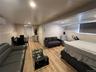 Open-concept living space featuring wood-finish flooring, recessed lighting, and white baseboards
