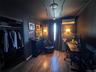 Room featuring wood-finish flooring, a built-in closet, a ceiling-mounted light fixture, and wall-mounted sconces