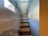 Staircase with wood-finish treads, painted risers, and a white paneled door