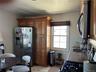 Kitchen featuring wood cabinetry, stainless steel appliances, a window with woven shade, and stone countertops