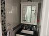 Bathroom with a white vanity, black speckled countertop, and an integrated white sink