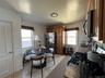 Kitchen featuring tile flooring, wood cabinetry, granite countertops, and a tiled backsplash