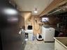 Utility area with exposed ceiling beams and a compact window