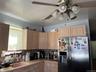 Kitchen featuring light wood-finish cabinetry, a built-in stainless steel refrigerator, and a mosaic tile backsplash
